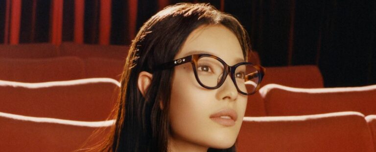 kobieta w okularach korekcyjnych siedząca w rzędzie foteli - Gucci